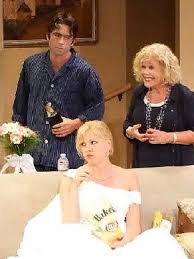 Three performers gathered around a sofa in Reasons to Live